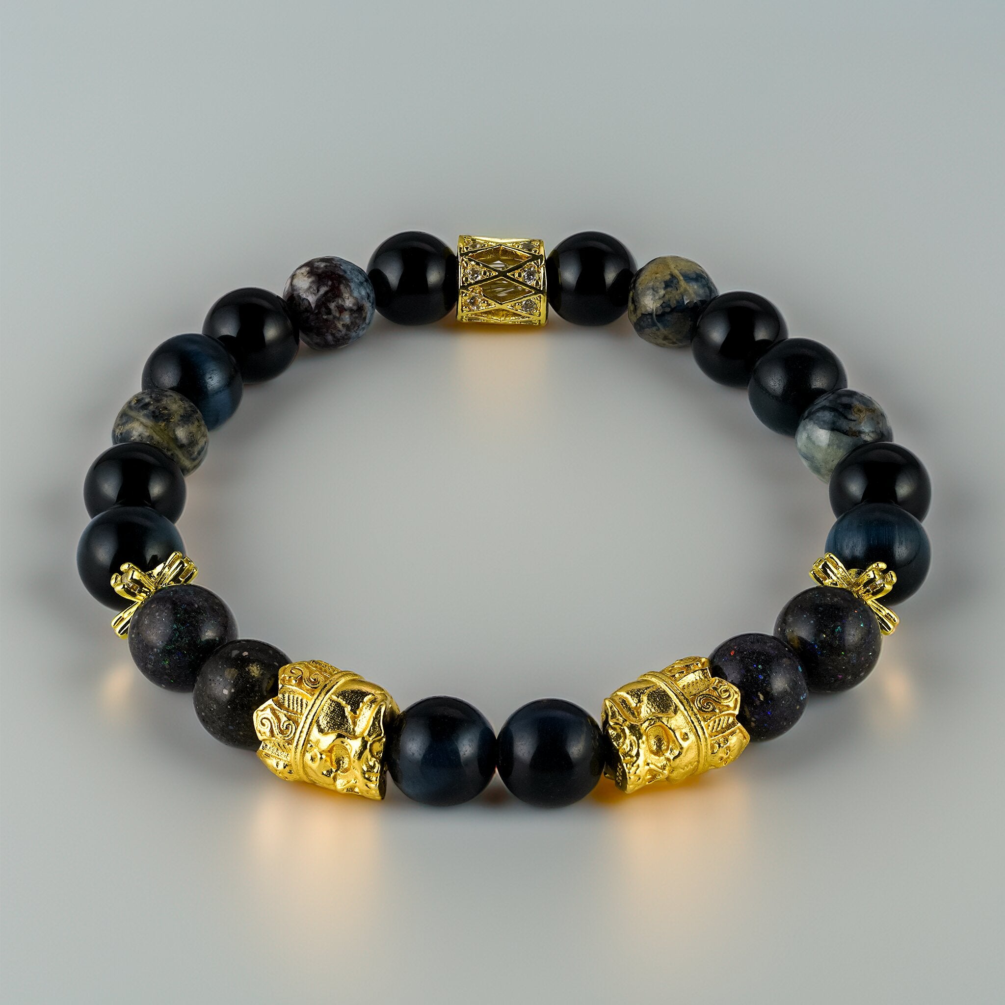 Memento Collection Mors Vincit Omnia skull bracelet by XOIAX with Blue Tiger Eye, Obsidian, Pietersite and Black Opal beads, twin 24K gold-plated skull charms