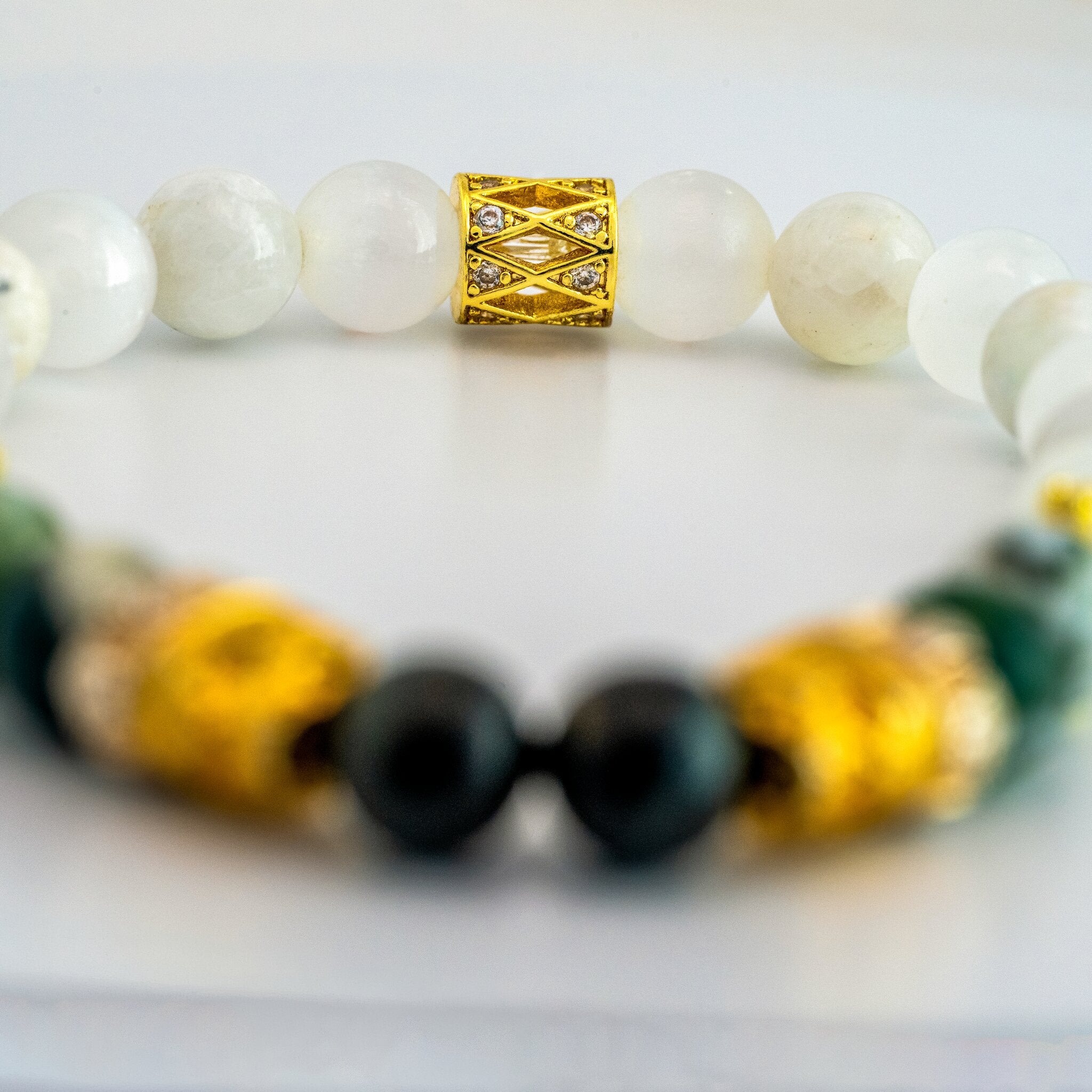 Memento Collection Memento Vivere skull bracelet by XOIAX with White Jade, Selenite, and Tree Agate beads, close-up back focus shot with gold-plated skull charm