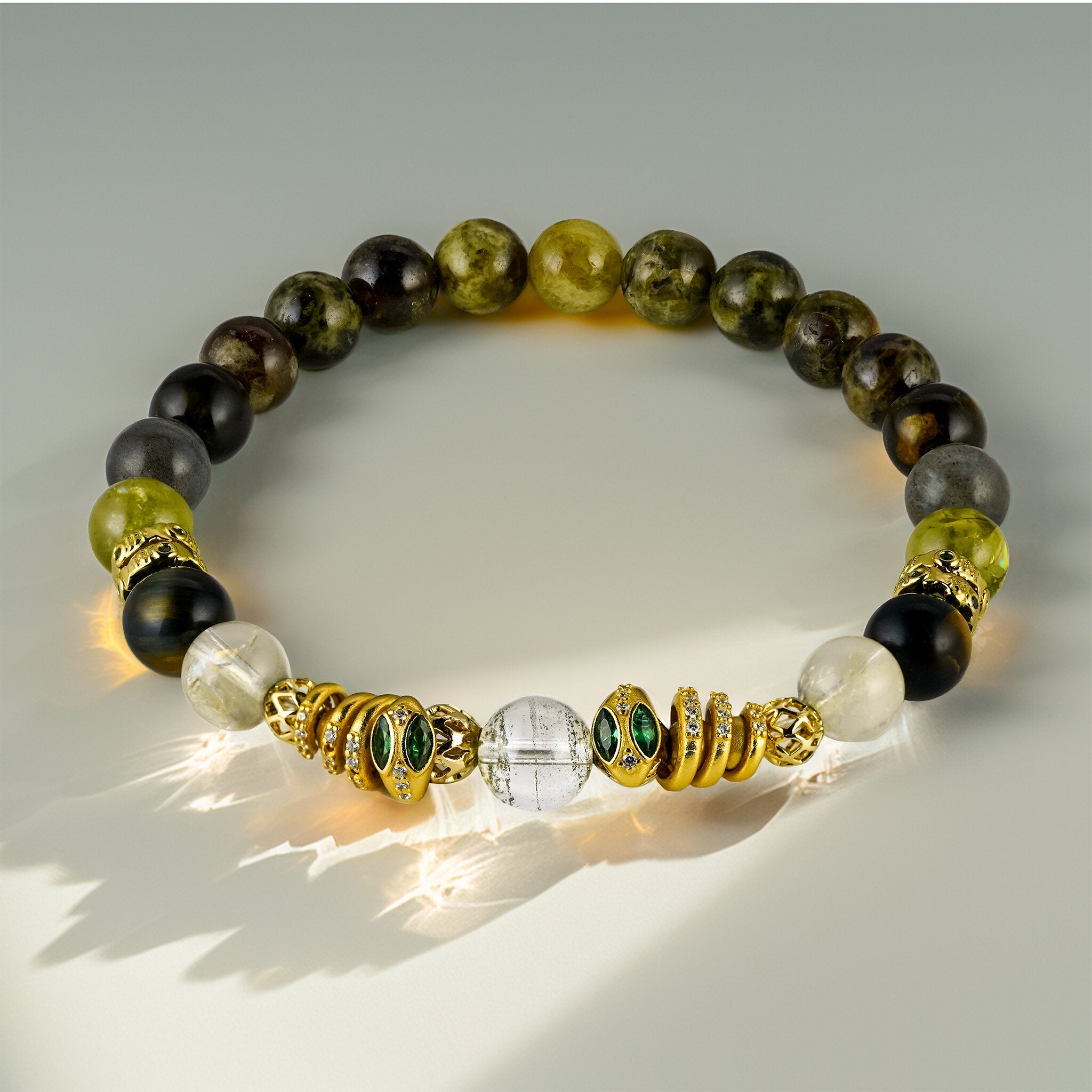 Secret Guardians Royal Serpents Collection Naga bracelet by XOIAX with Collector-Grade Green Phantom Quartz and emerald-eyed 24k gold serpent charms, a feng shui bracelet guarding hidden treasures